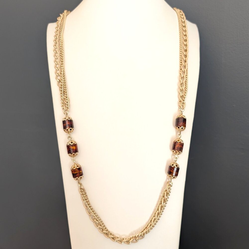 Long multi gold tone chain necklace with root beer toned beads